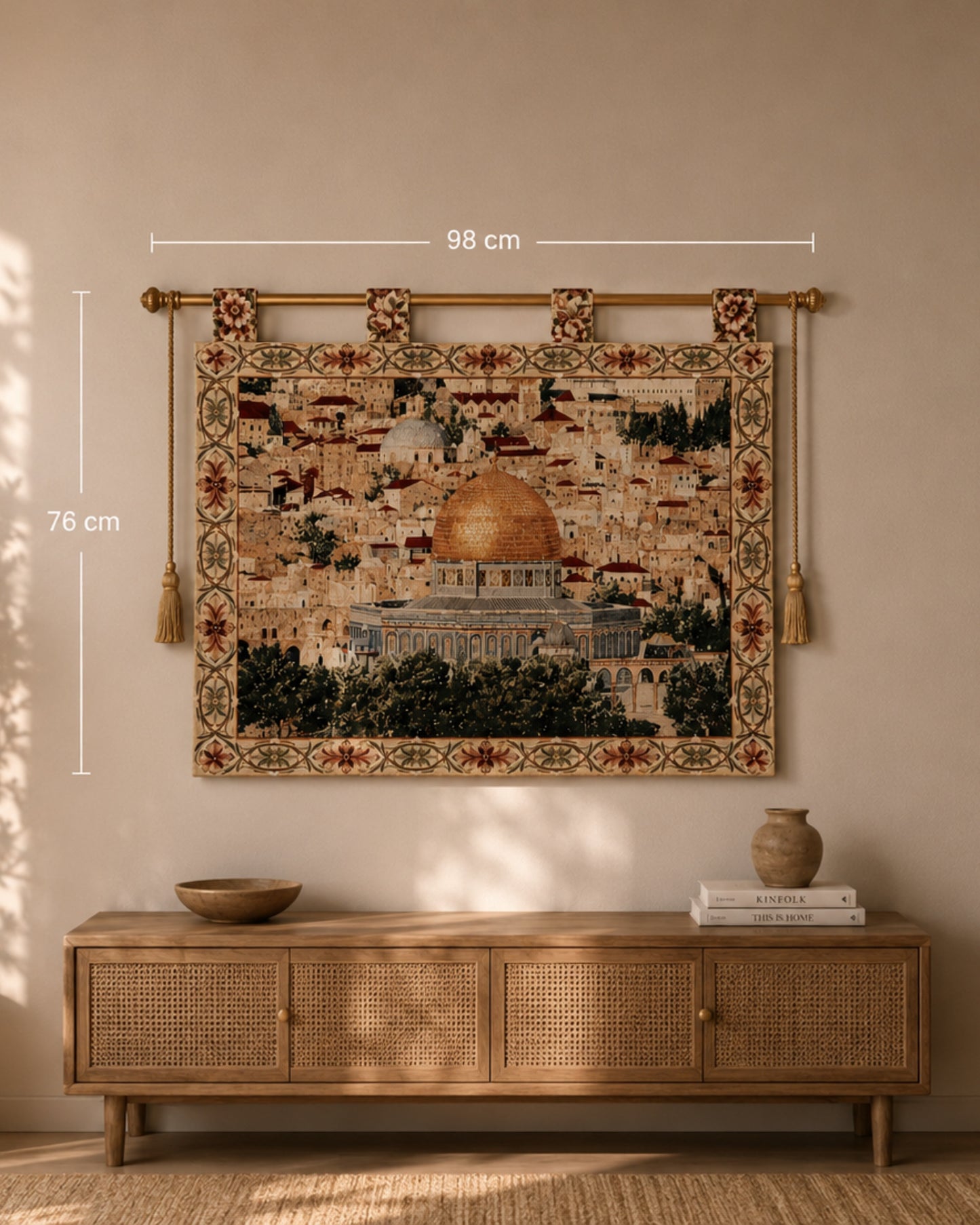Al Aqsa Mosque woven wall tapestry displayed above a natural wood console table in a warm, neutral-toned living room. The tapestry features the golden Dome of the Rock and intricate floral borders, with size dimensions shown as 98 cm x 76 cm for scale reference.