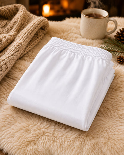 Folded women's white cotton capri leggings styled with cozy winter décor, featuring breathable cotton fabric and comfortable layering for modest outfits.