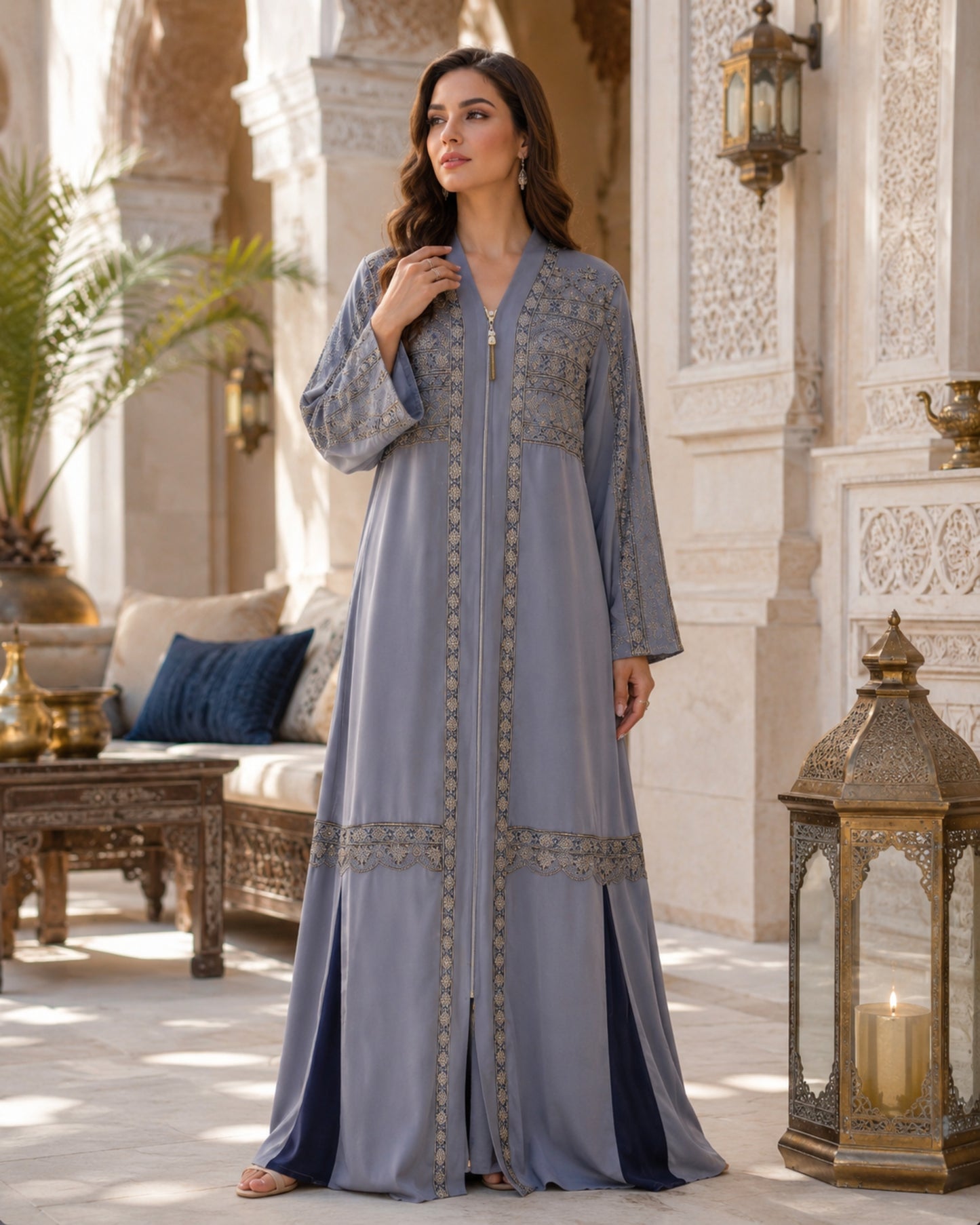 Woman in a long, light blue dress with intricate patterns standing in an ornate courtyard.

